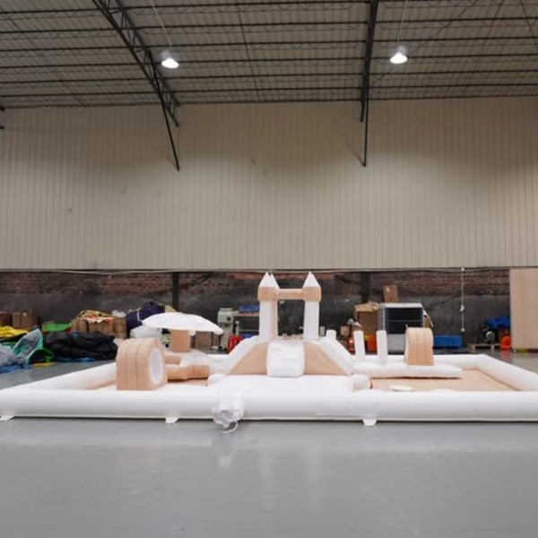 Grande zone de jeu gonflable avec toboggan, château et murs rembourrés